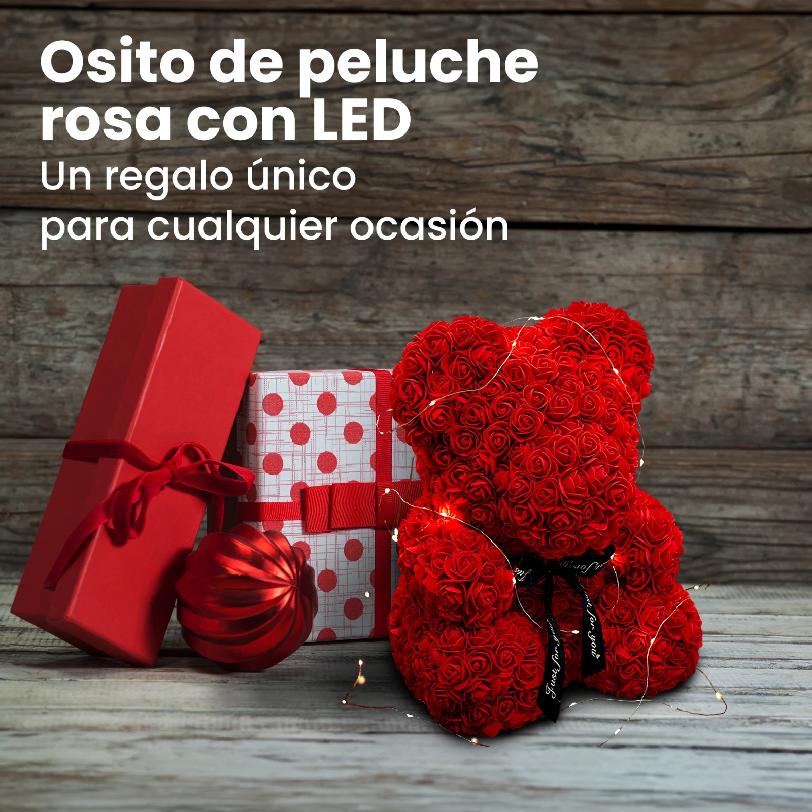 Un osito de peluche con una rosa roja, envuelto en luces LED, junto a dos cajas de regalo y una chucher&iacute;a.