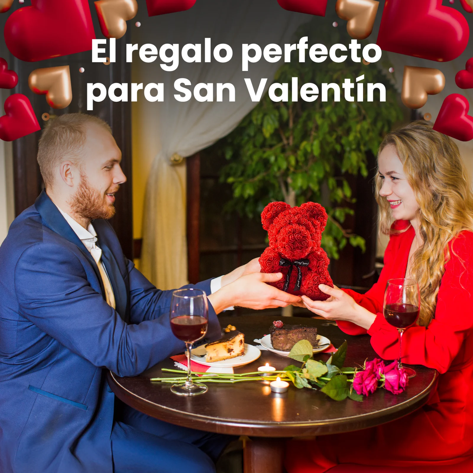 La pareja sonr&iacute;e sentada a la mesa de un restaurante y el hombre entrega a la mujer un osito de peluche rojo con rosas