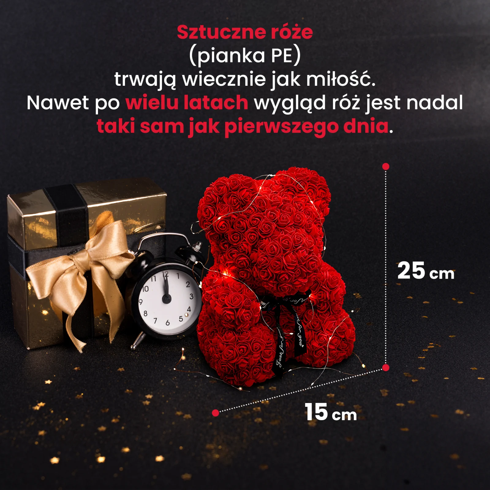Un osito de peluche con una rosa roja, iluminado por LED, junto a una caja de regalo dorada y un reloj negro.