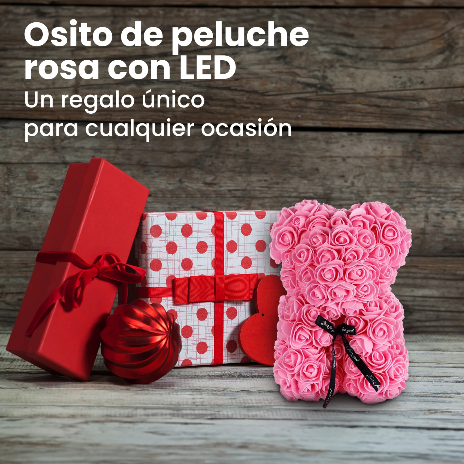 un osito de peluche rosa junto a dos cajas de regalo y una chucher&iacute;a
