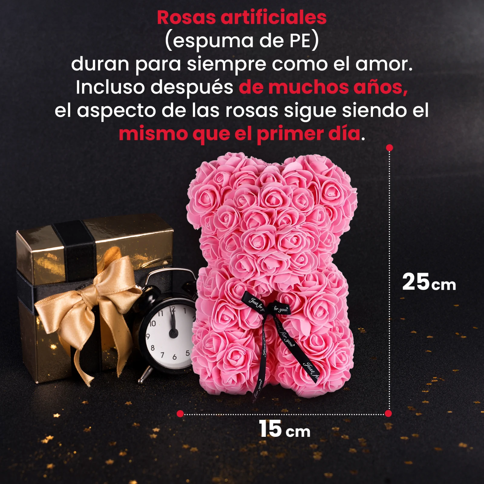 un osito de peluche rosa junto a una caja de regalo dorada y un reloj negro