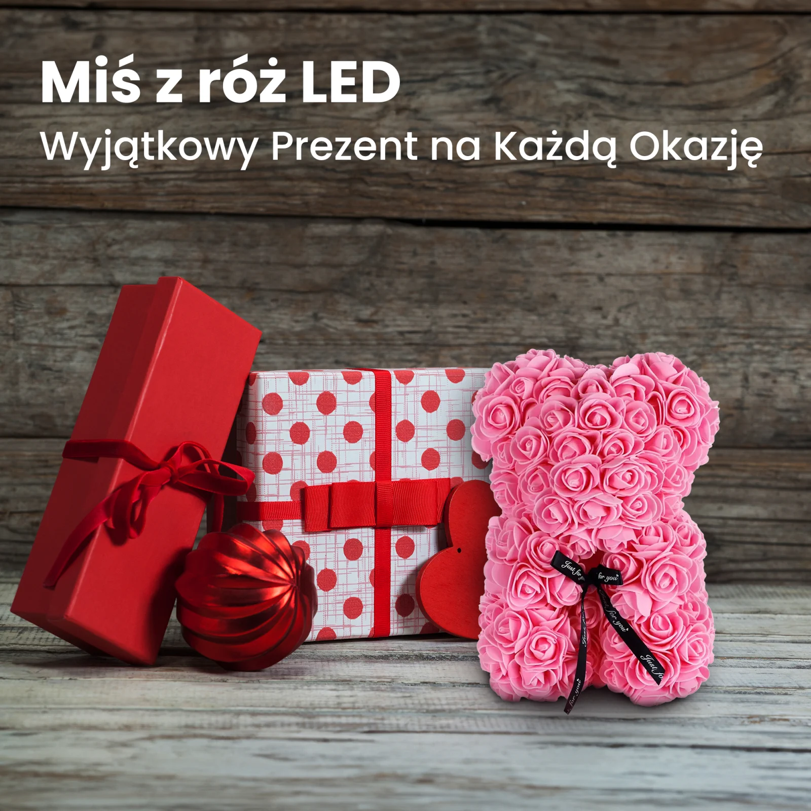 różowy miś z róż stoi obok dwóch pudełek prezentowych i bombki