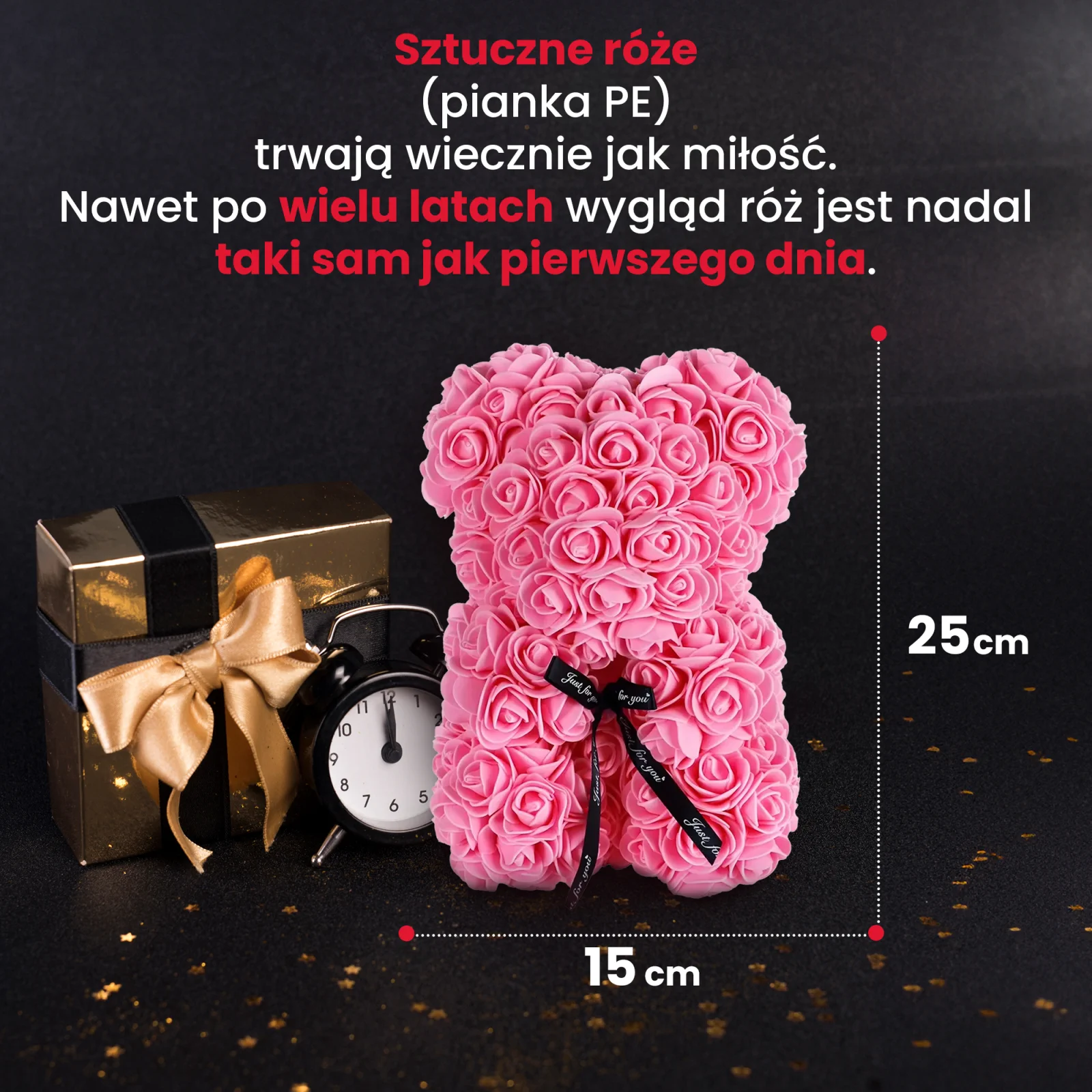 różowy miś z róż stoi obok złotego pudełka prezentowego i czarnego zegara
