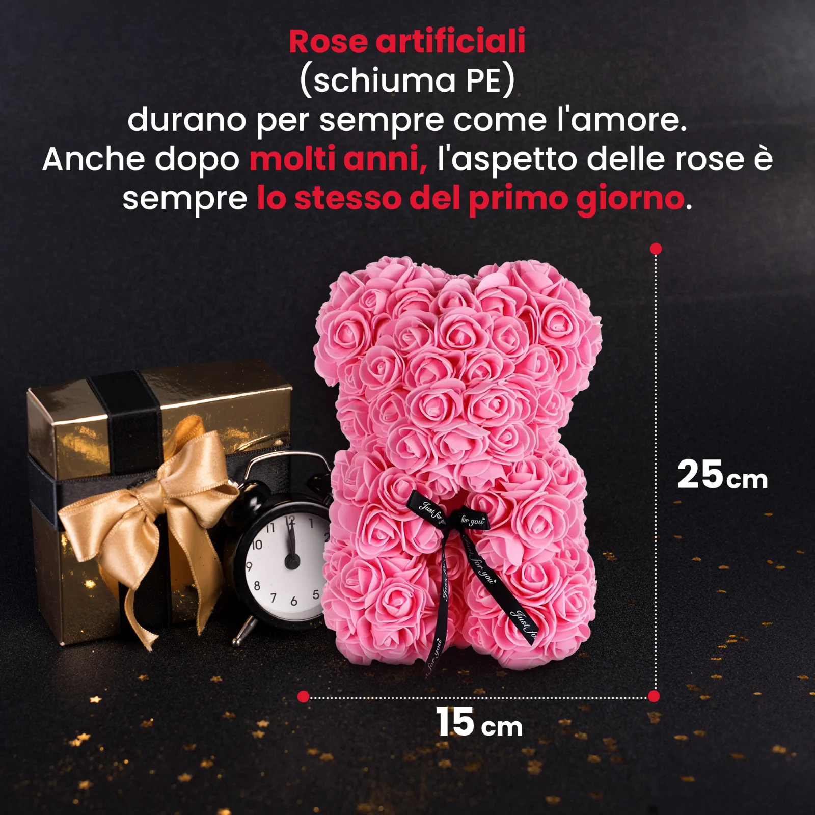 l'orsacchiotto rosa si trova accanto a una confezione regalo dorata e a un orologio nero