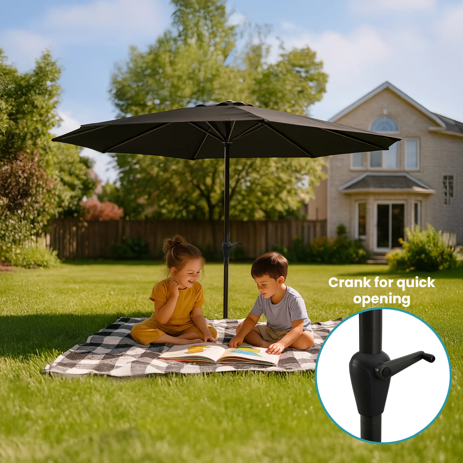 Dos niños pequeños sentados en una manta bajo un gran paraguas negro extralink, leyendo un libro.