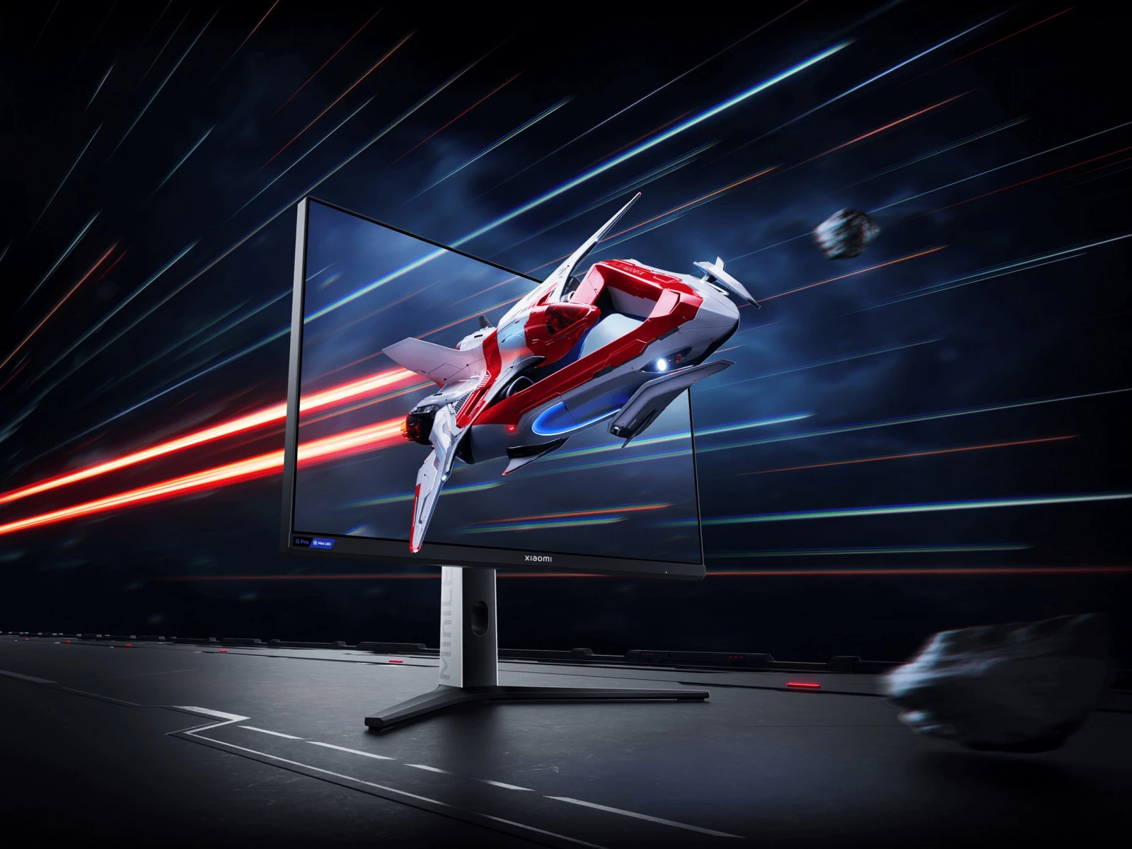 Monitor gaming colocado num ambiente de trabalho escuro, exibindo uma nave espacial em voo rápido