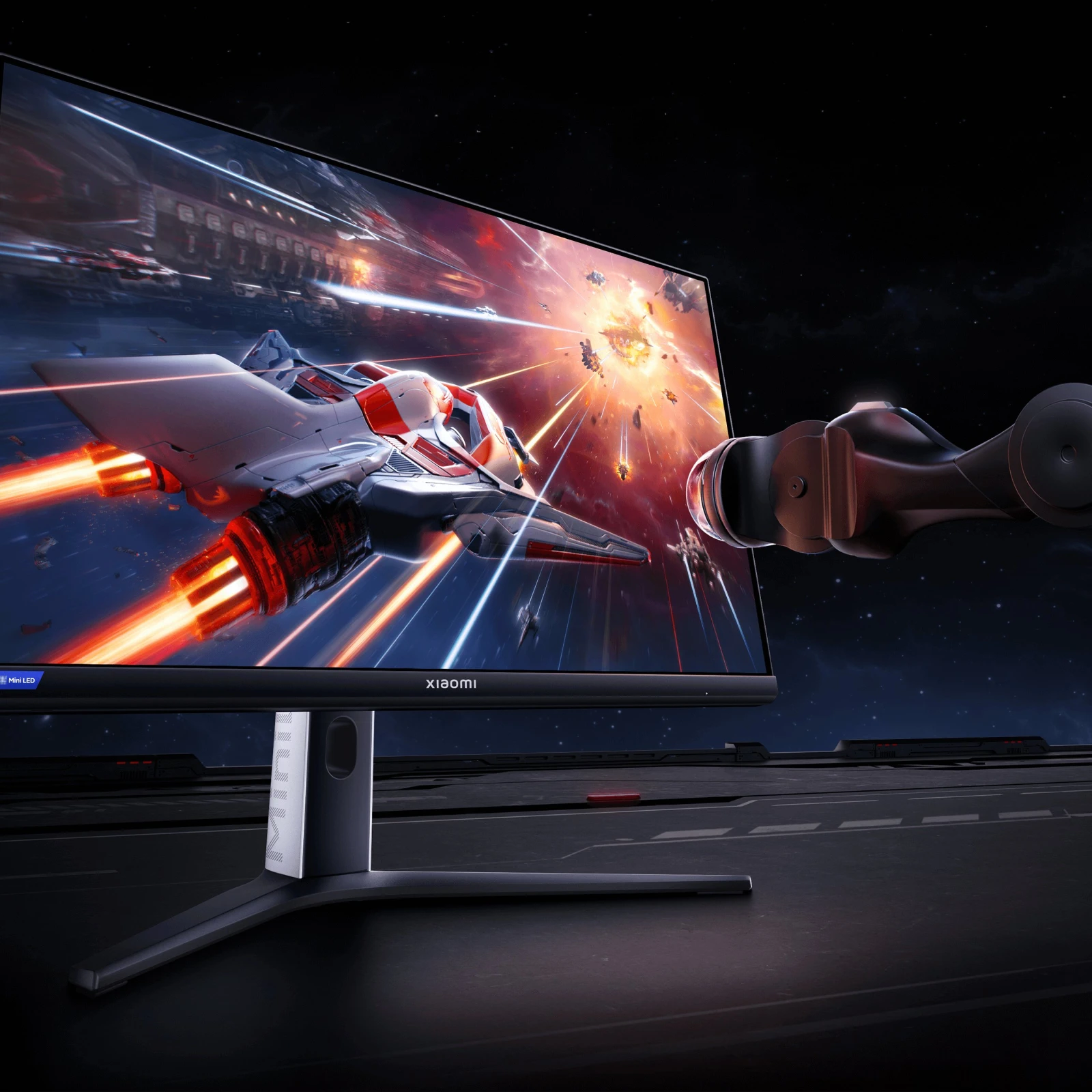 Monitor gaming com um planeta em explosão no ecrã, ao lado do qual flutua um braço robótico futurista