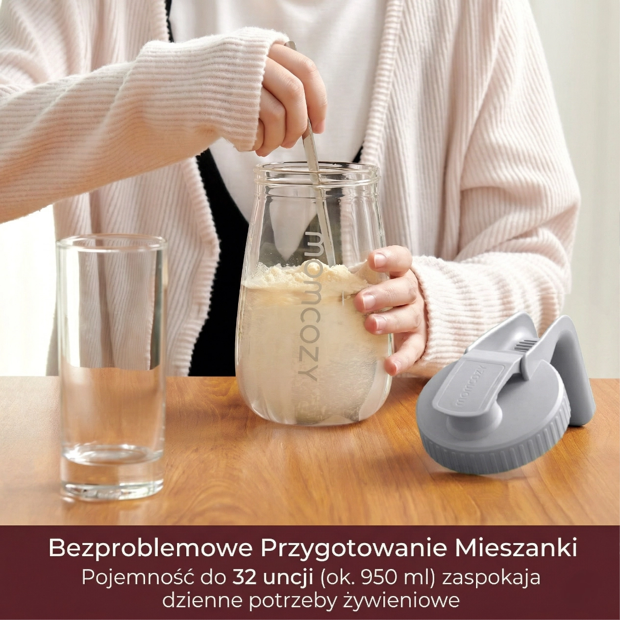 Žena míchá prášek do mléka v průhledné nádobě, vedle se nachází sklenice a příslušenství k nalévání