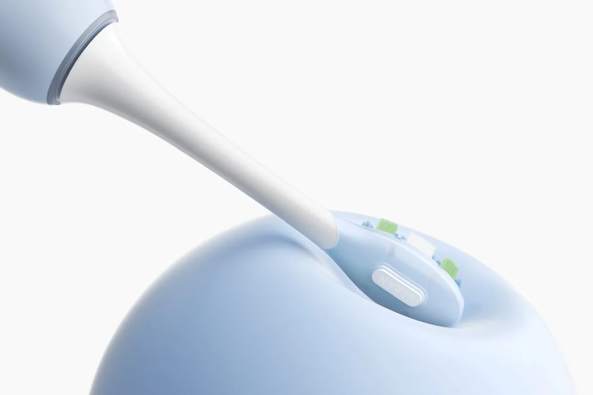 Testina di spazzolino elettrico posizionata in un manico ergonomico azzurro chiaro su sfondo bianco