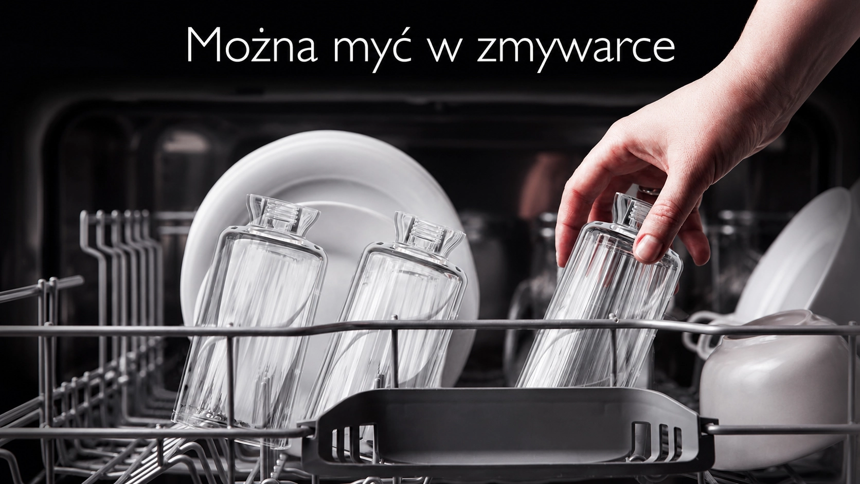 Lidská ruka vkládá průhlednou podlouhlou nádobu do horního koše myčky vedle bílých talířů a šálků.