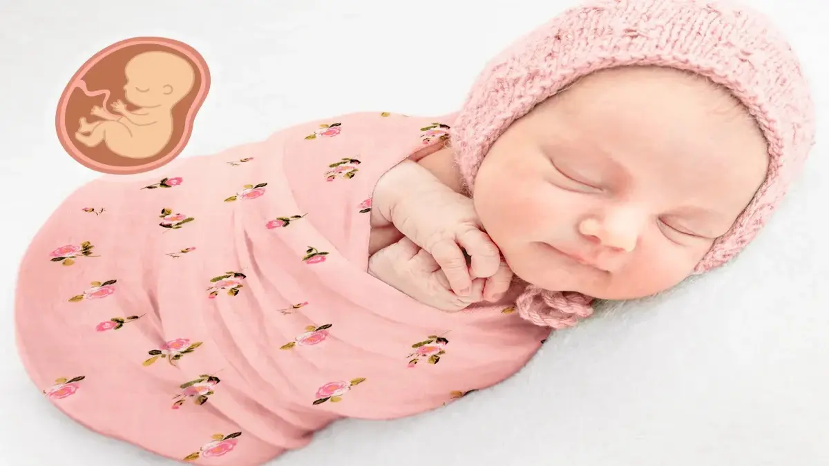 Recém-nascido envolvido num envolvente rosa com padrão floral, a dormir com um gorro de malha na cabeça.