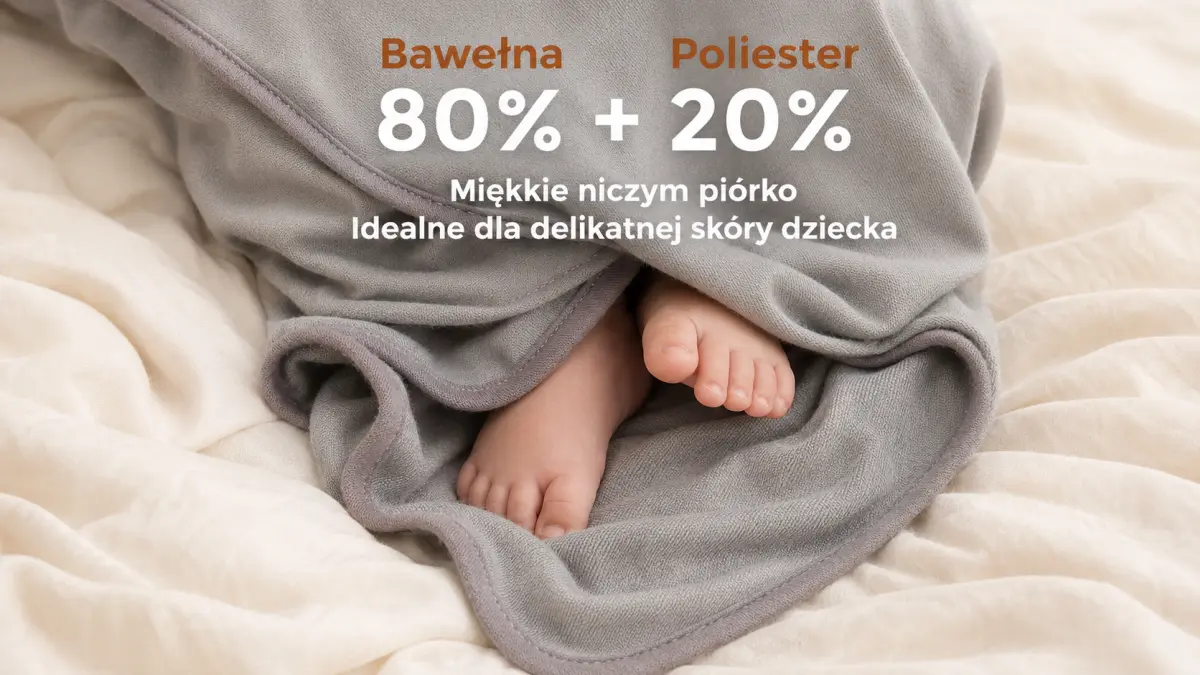 Pezinhos de beb&ecirc; envoltos em uma toalha cinza macia sobre roupa de cama clara.