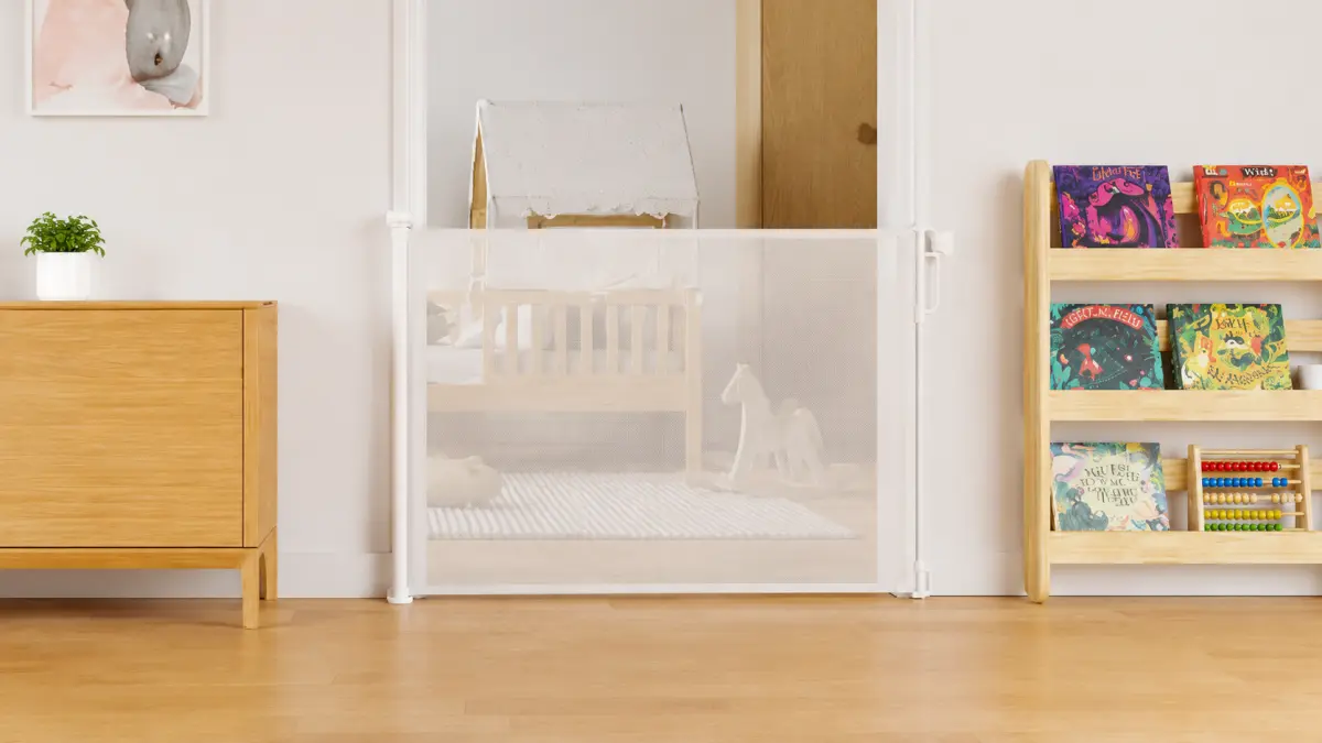Barrera de seguridad blanca en la entrada de una habitaci&oacute;n infantil con una cama de madera y una estanter&iacute;a para libros.