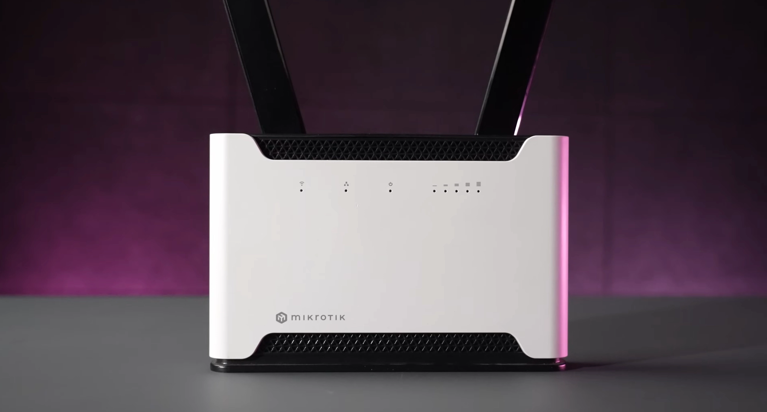 Router con retroiluminación rosa e indicadores LED visibles en el panel frontal