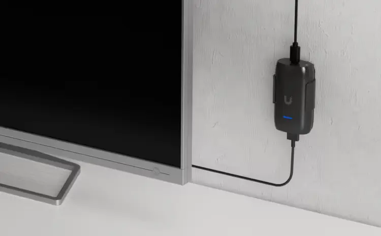 Urządzenie zamontowane na telewizorze, połączone kablem