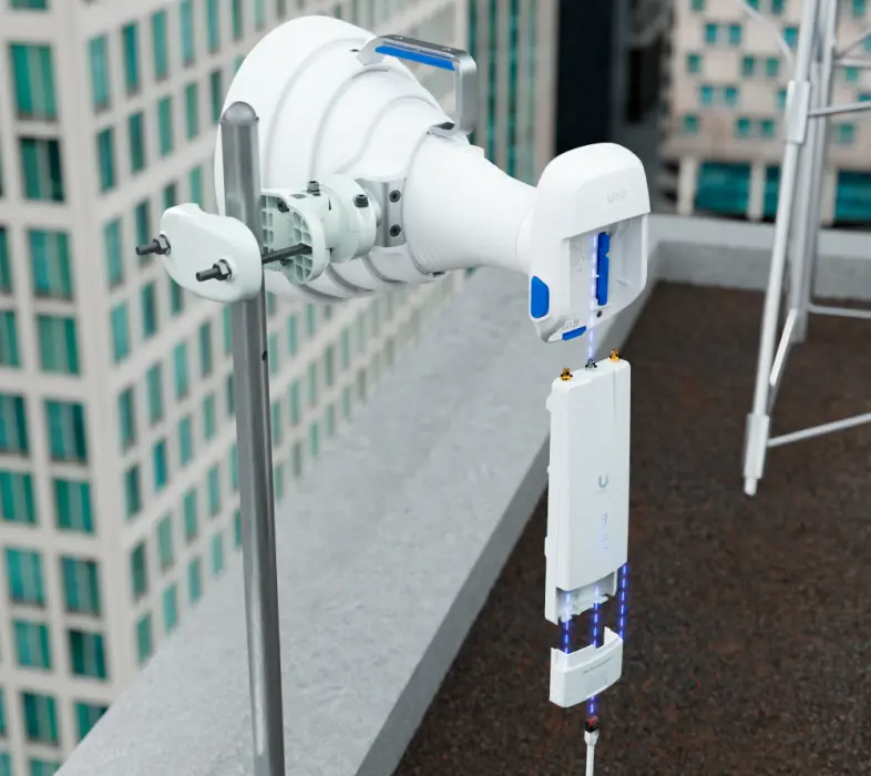 Точка доступа Ubiquiti Wave MLO 5, подключенная к большой направленной антенне, установленной на мачте на крыше здания, с видимой активной светодиодной подсветкой
