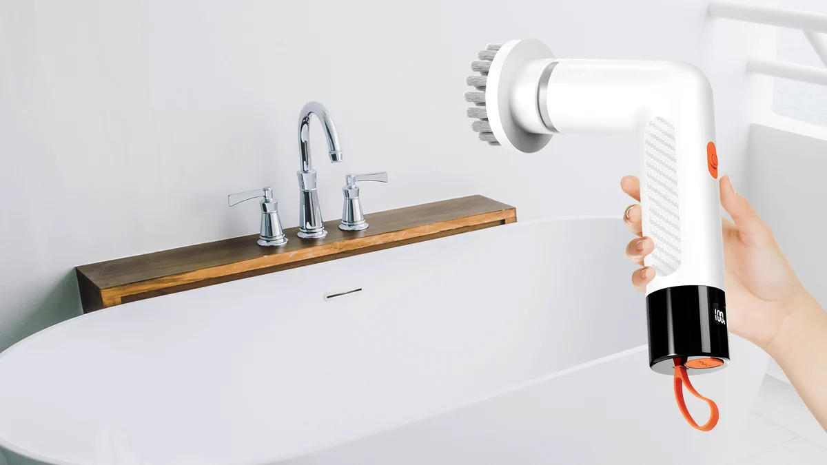 persona que sostiene extralink mini cepillo de limpieza en el fondo bañera blanca con grifo sobre encimera de madera