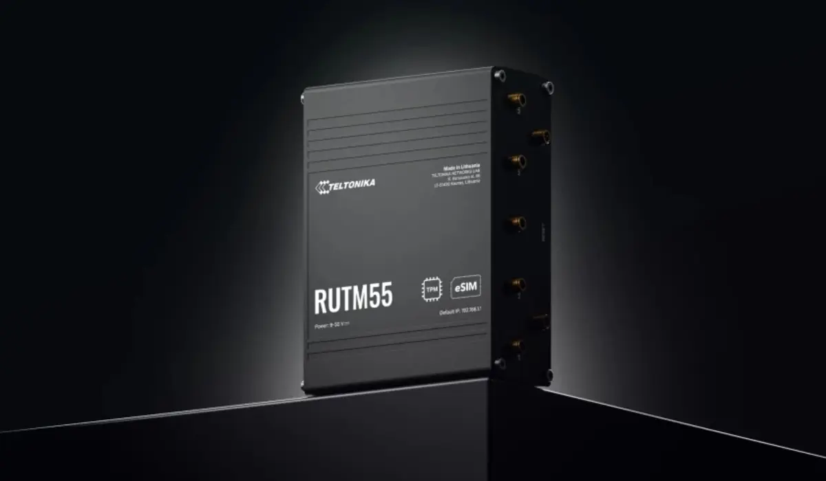 O router Teltonika RUTM55 num espa&ccedil;o escuro, mostrando uma vista lateral do dispositivo, com antenas e marca&ccedil;&otilde;es, contra um fundo escuro. 