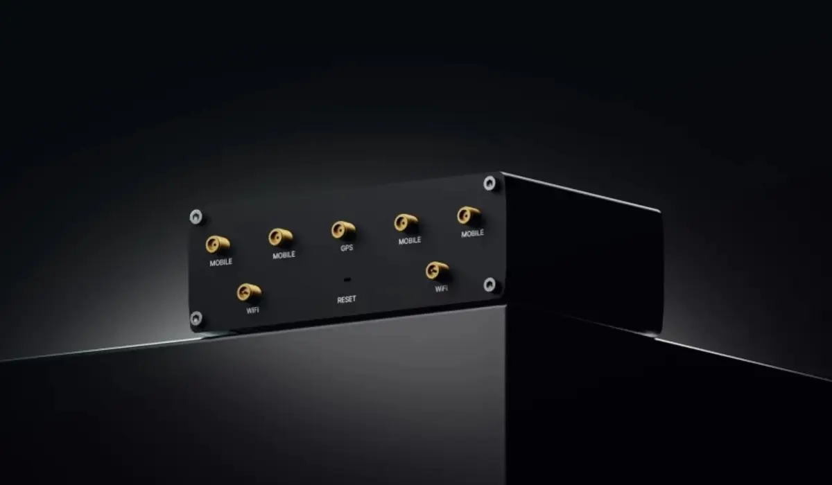 Grande plano da parte de tr&aacute;s do router Teltonika RUTM55 com portas e antenas vis&iacute;veis (m&oacute;vel, GPS, WiFi), com um fundo escuro.