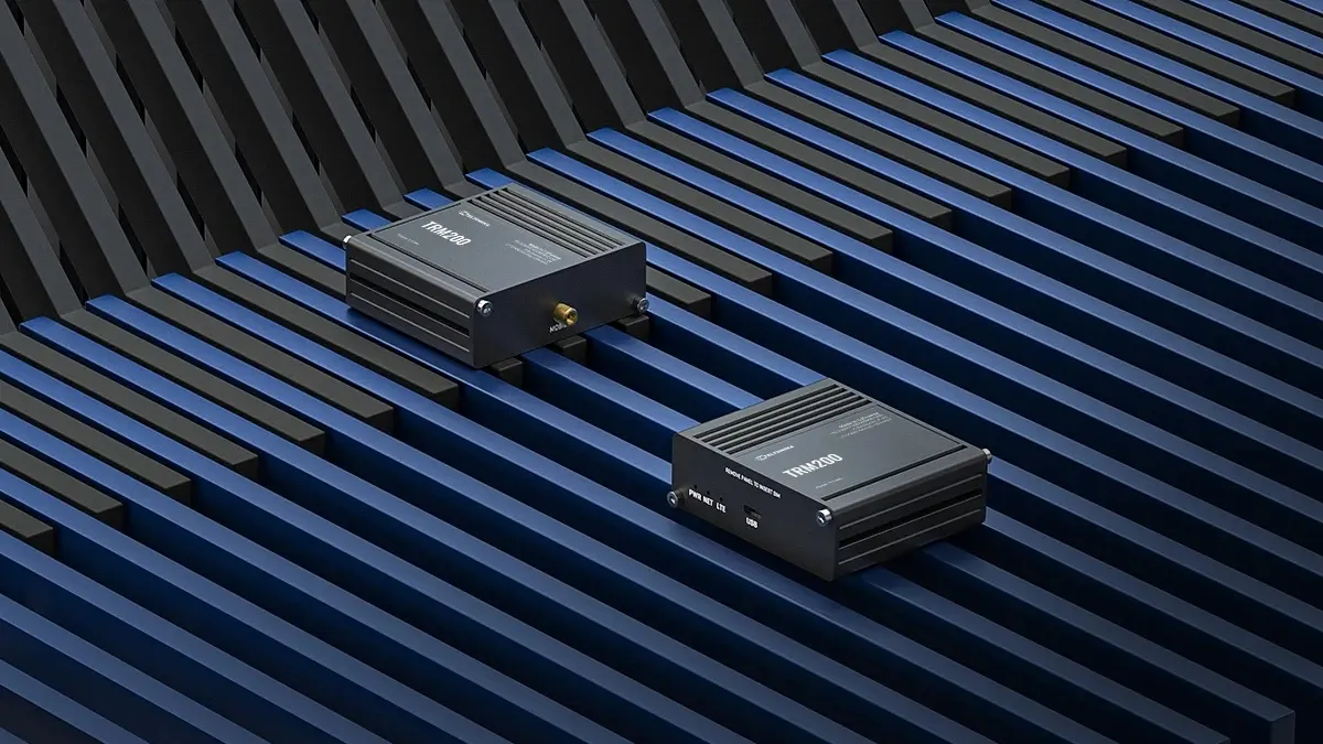 Vista di due modem Teltonika TRM200 su uno sfondo a strisce blu, con le porte e l'antenna chiaramente visibili