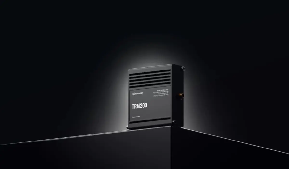 Vista laterale del modem Teltonika TRM200, su sfondo scuro, con il logo Teltonika sull'alloggiamento e la designazione del modello.