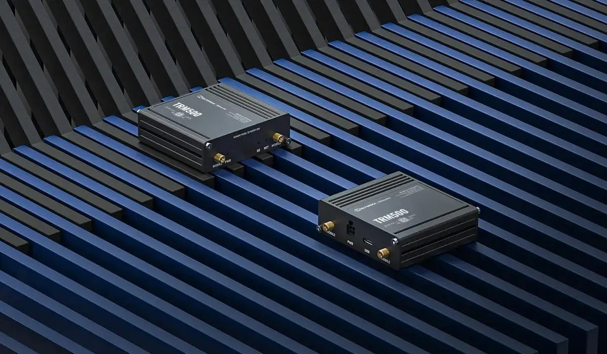 Dos módems Teltonika TRM500 colocados uno al lado del otro, con una vista de los puertos y antenas, sobre un fondo de barras azules.