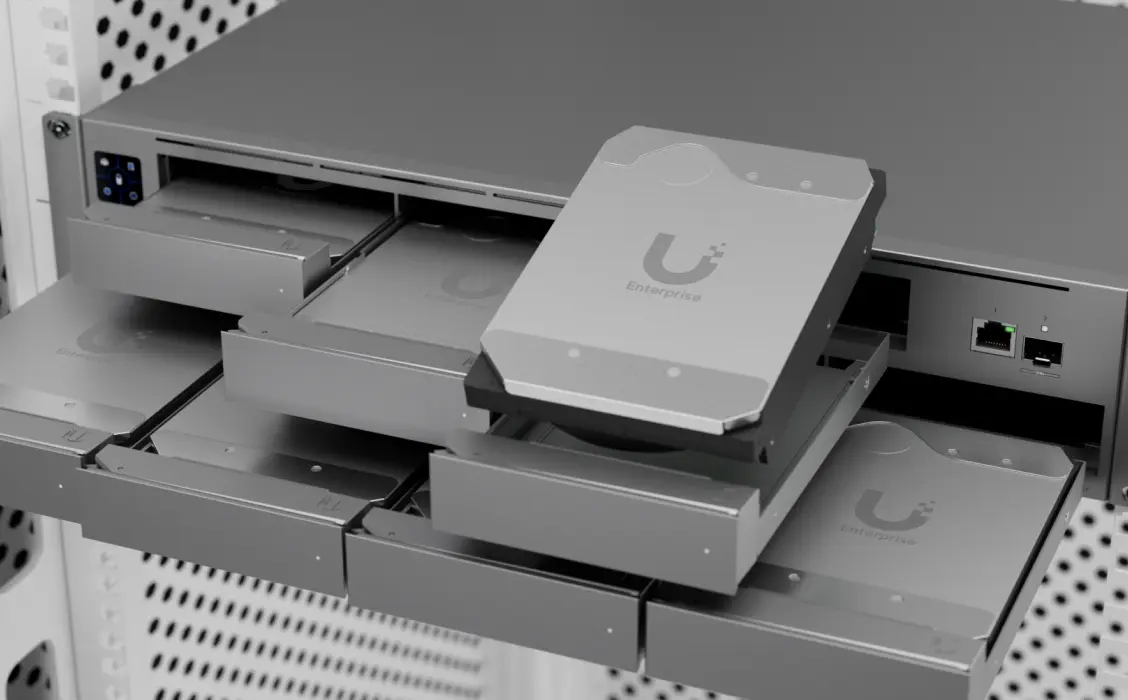 Dyski Ubiquiti Enterprise w szufladach serwera, widoczna instalacja z portami sieciowymi i zasilaniem