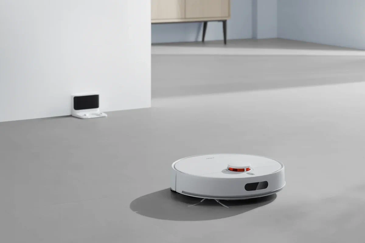 Rob&ocirc; de limpeza branco Xiaomi S40C em um ch&atilde;o cinza ao lado da esta&ccedil;&atilde;o de carregamento na parede