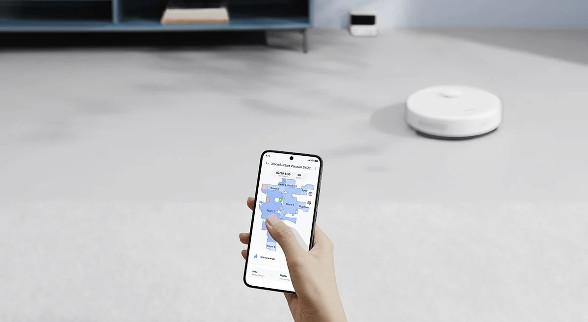 M&atilde;o segurando um smartphone com aplicativo m&oacute;vel para controle remoto e visualiza&ccedil;&atilde;o do mapa de limpeza