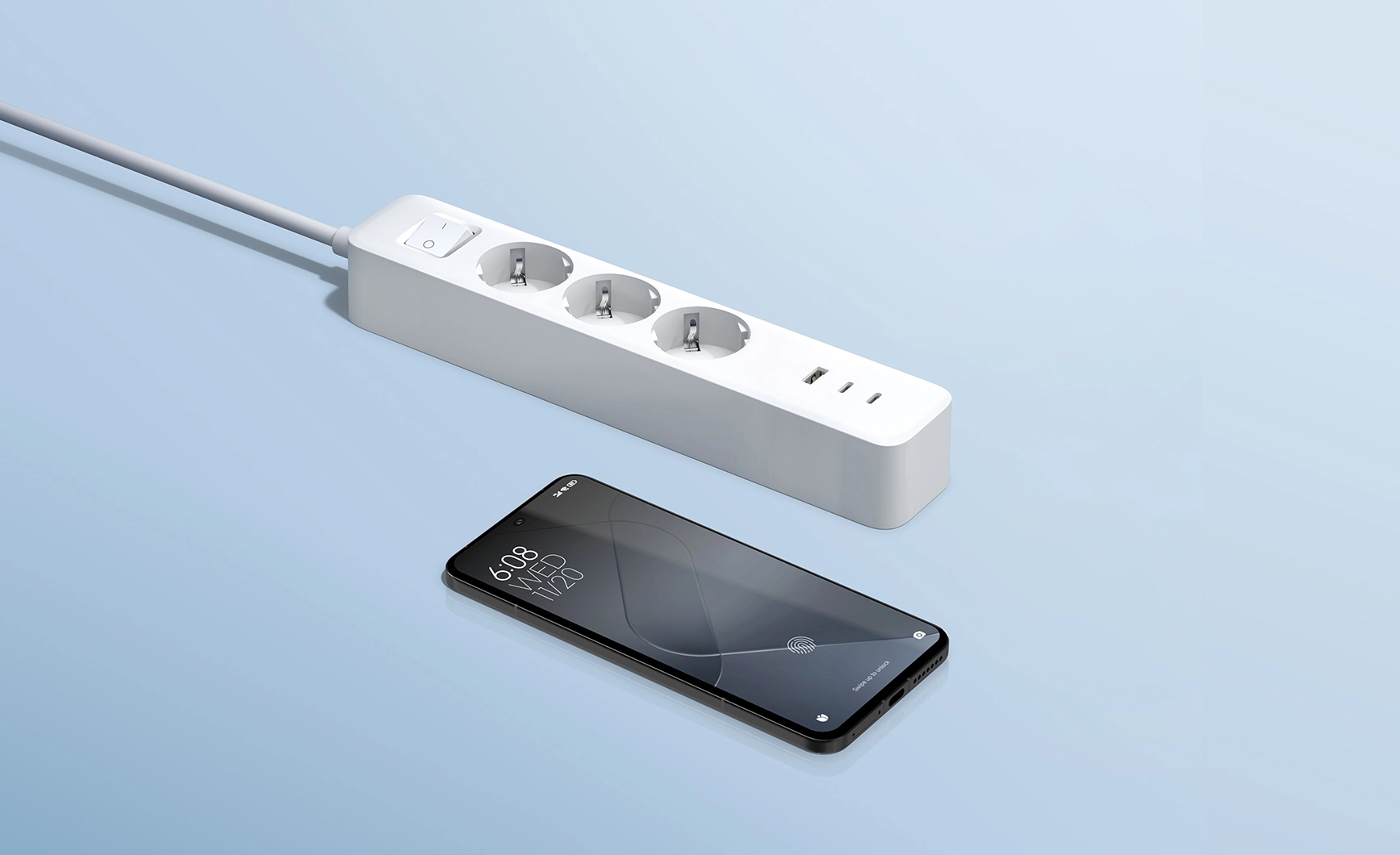 Zbliżenie na listwę zasilającą Xiaomi z trzema gniazdami, portami USB i włącznikiem, obok telefonu