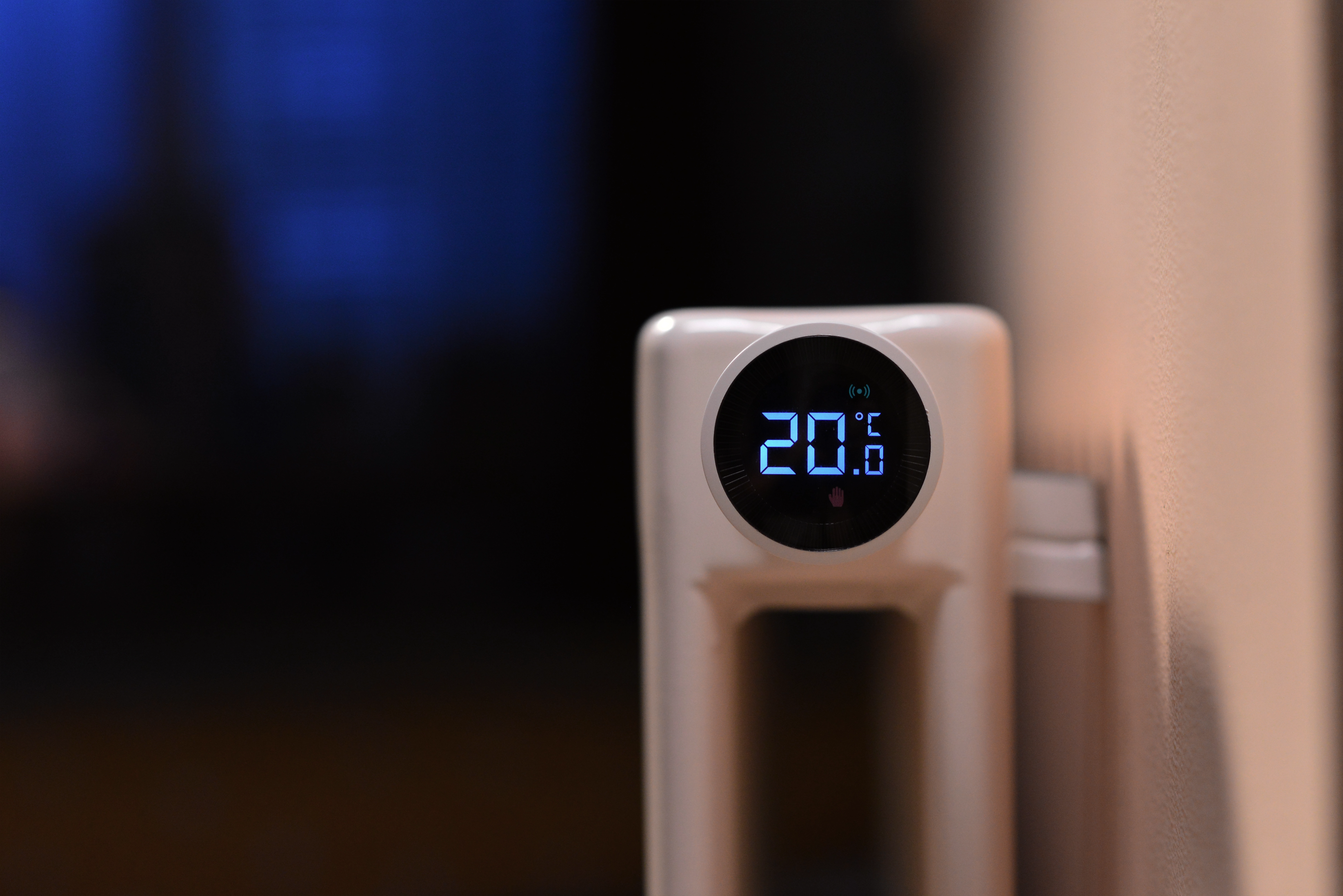 Termostat Aqara Smart Radiator zamontowany na grzejniku, z cyfrowym wyświetlaczem pokazującym temperaturę 20°C.