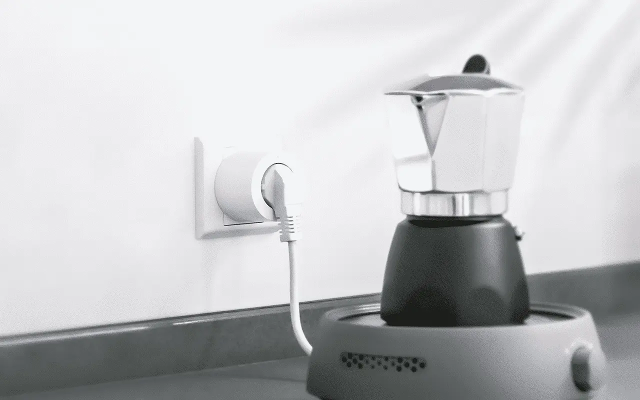 Ekspres do kawy podłączony do gniazdka elektrycznego w nowoczesnej kuchni