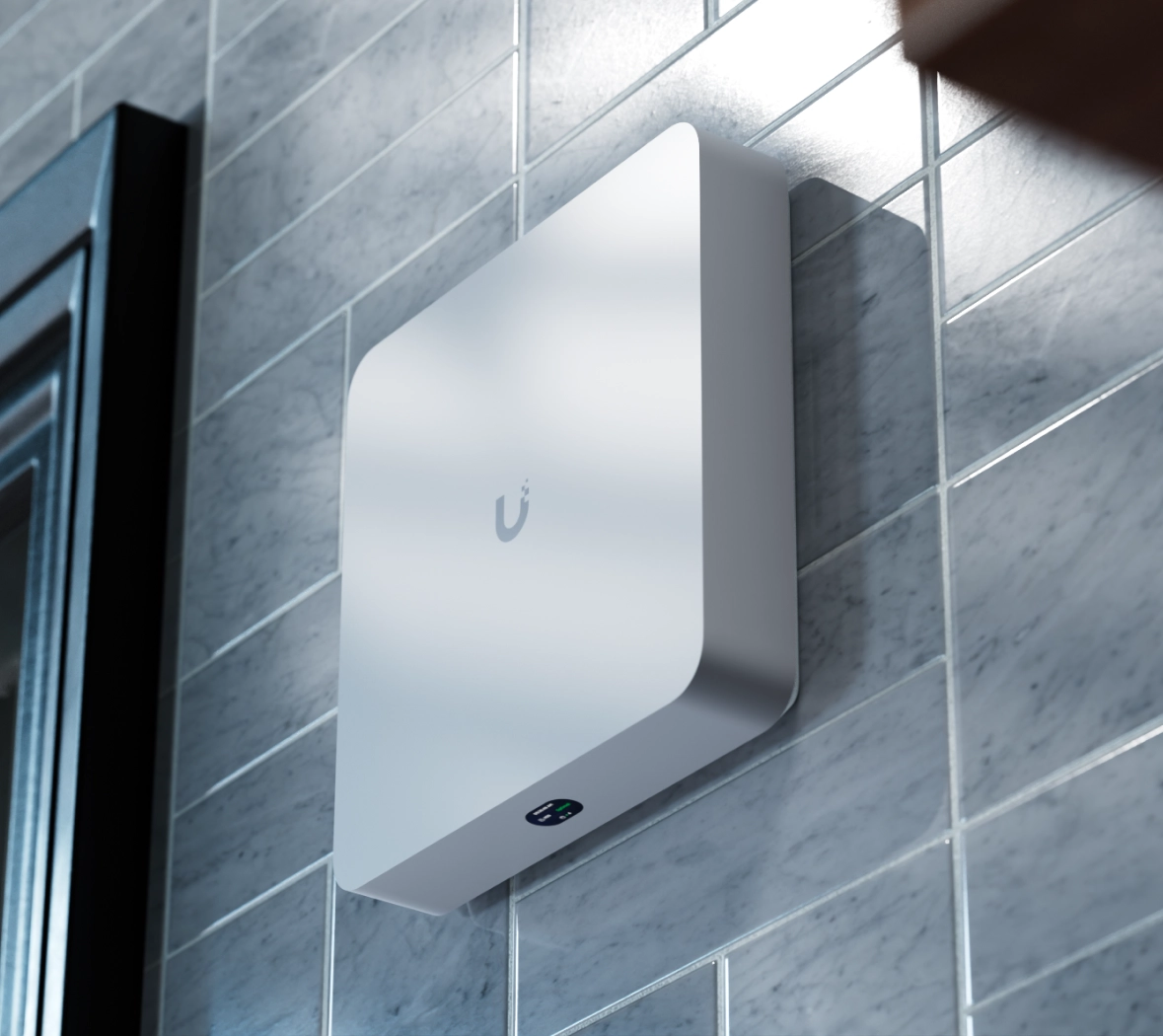 Unidade Ubiquiti UNVR Instant montada numa parede numa sala iluminada. Log&oacute;tipo LED e estado vis&iacute;veis a partir da frente