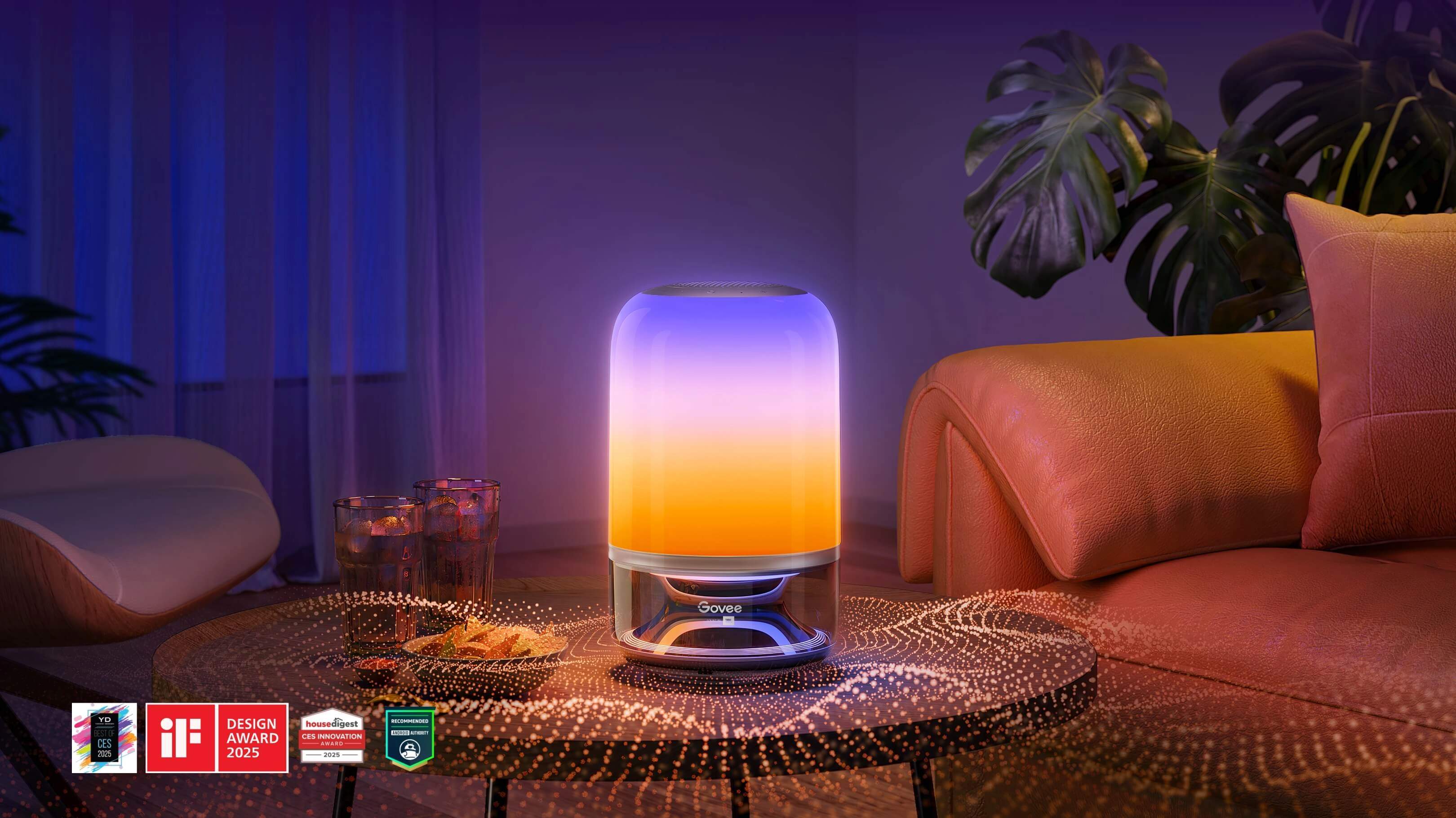 Lampa LED Govee H6020 Table Lamp 2 Pro świecąca gradientem fioletowo-pomarańczowym na stoliku w salonie, obok szklanki i roślina w tle, na dole widoczne logotypy nagród za design