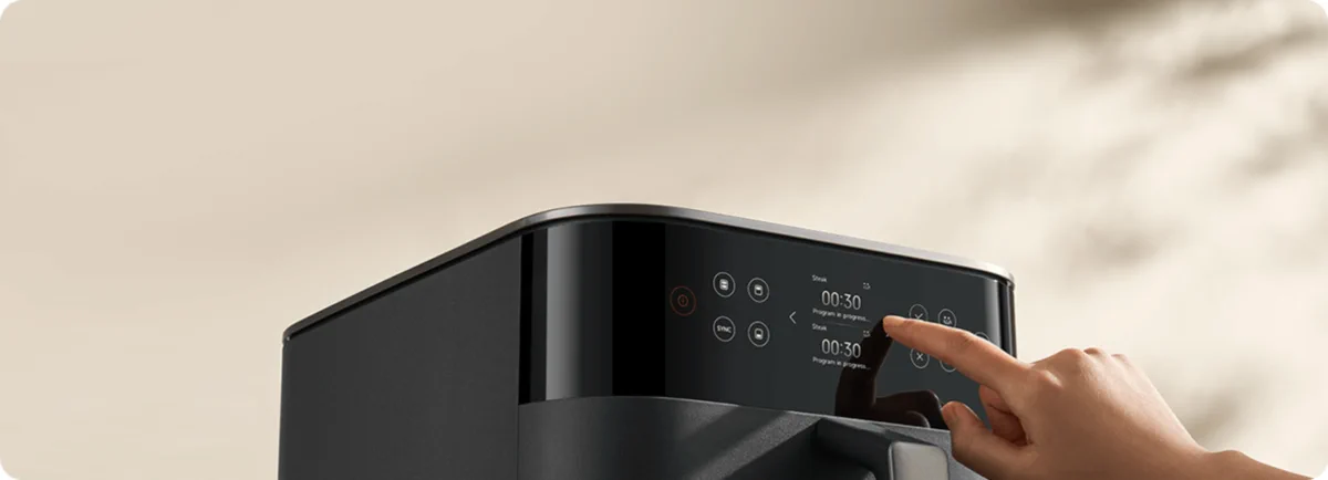 Close-up of the black touch control panel of the Xiaomi air fryer with a 00:30 time display operated by finger