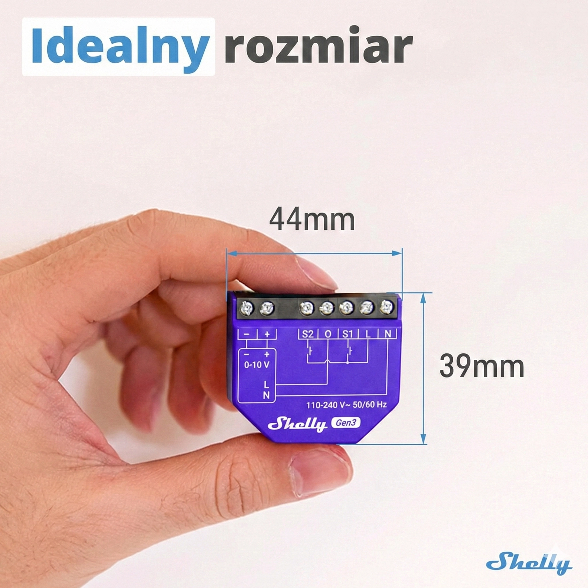 Urządzenie Shelly EM trzymane w ręce, widoczne porty z oznaczeniami, w tle neutralna przestrzeń