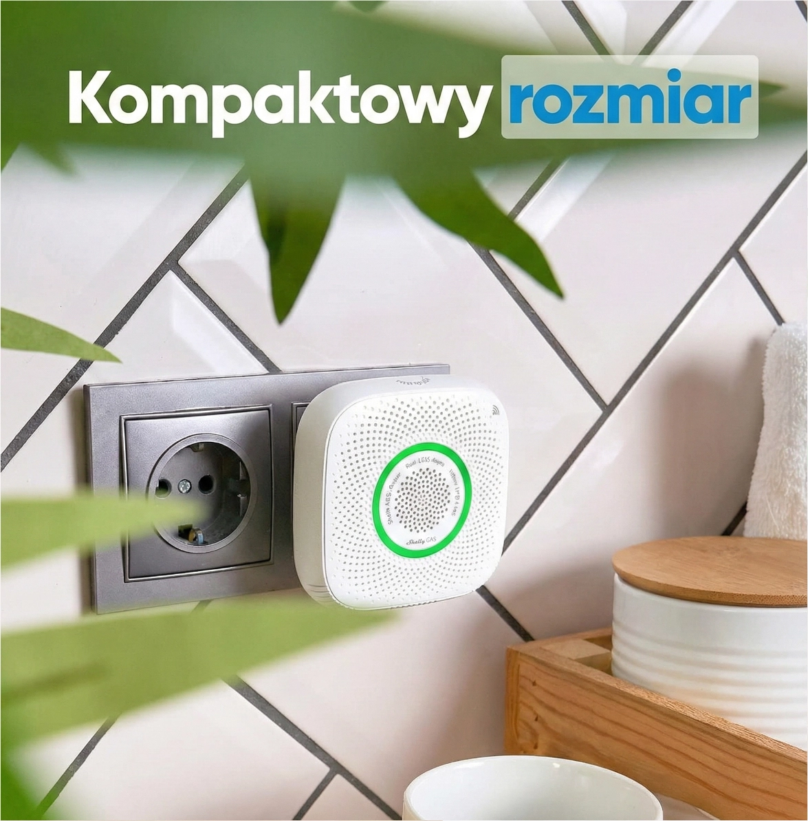 Kompaktowy czujnik gazu Shelly włożony w gniazdko, z zieloną diodą. Tło to białe płytki i roślinność