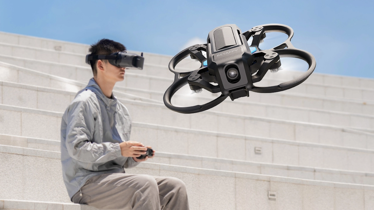 Mężczyzna siedzący na schodach z goglami VR i kontrolerem, sterujący dronem BetaFPV Aquila20