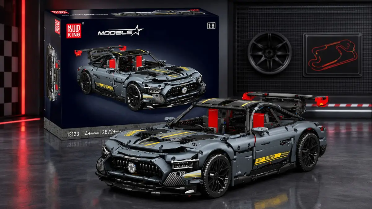 Szary klockowy model auta sportowego z pudełkiem na tle garażu wyścigowego