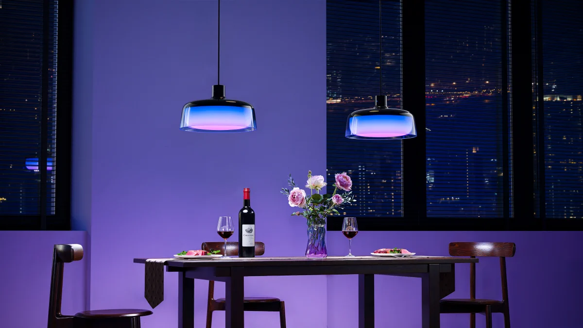 Two hanging H60C1 lamps glowing blue above an elegant table with wine and flowers