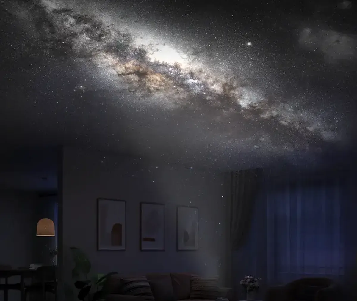 Proyección realista de la Vía Láctea en el techo de un salón oscuro sobre el sofá.