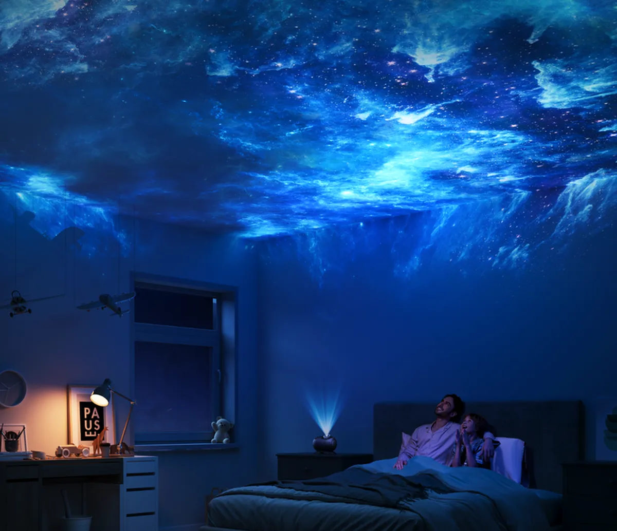 Proyección azul de una nebulosa que llena todo el techo sobre la cama en el dormitorio.