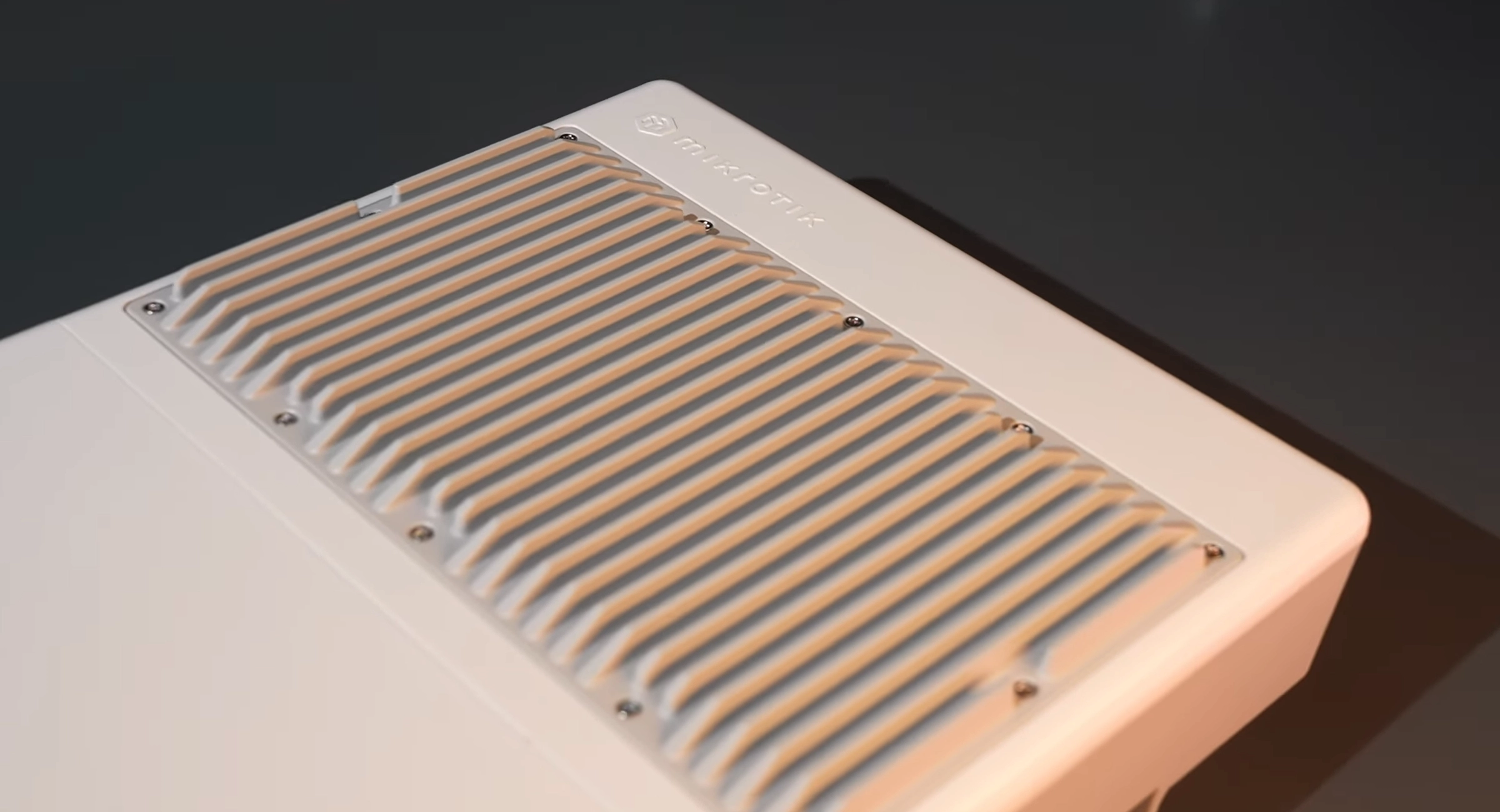 W pełnym widoku Mikrotik NetPower Lite 8P, na ciemnym tle, widoczne są porty oraz detale designu