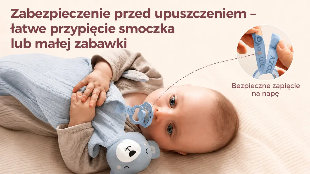 Bambino sdraiato con la copertina blu a forma di orsetto, ciuccio fissato con una cinghia di sicurezza contro la caduta.