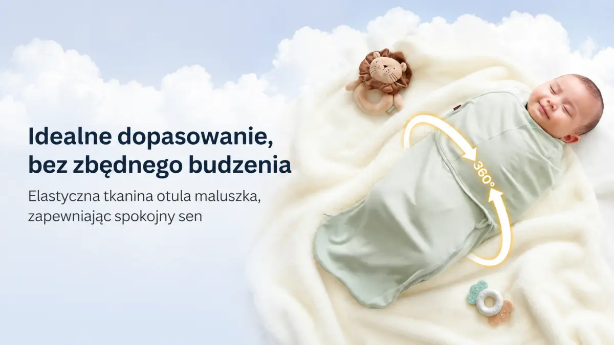 A sleeping baby in a light green swaddle lies on a fluffy blanket next to rattles