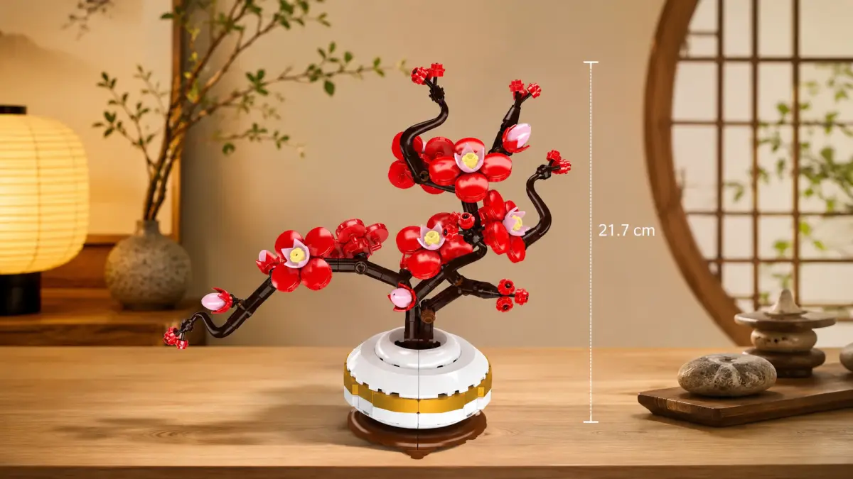Ramo de ameixeira de blocos com flores vermelhas num vaso branco sobre uma mesa de madeira