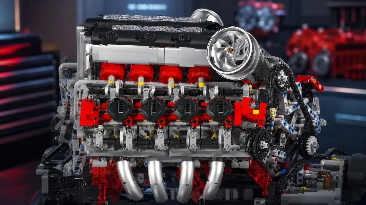 Primo piano del lato di un motore V8 in mattoncini con cilindri rossi e collettori argentati