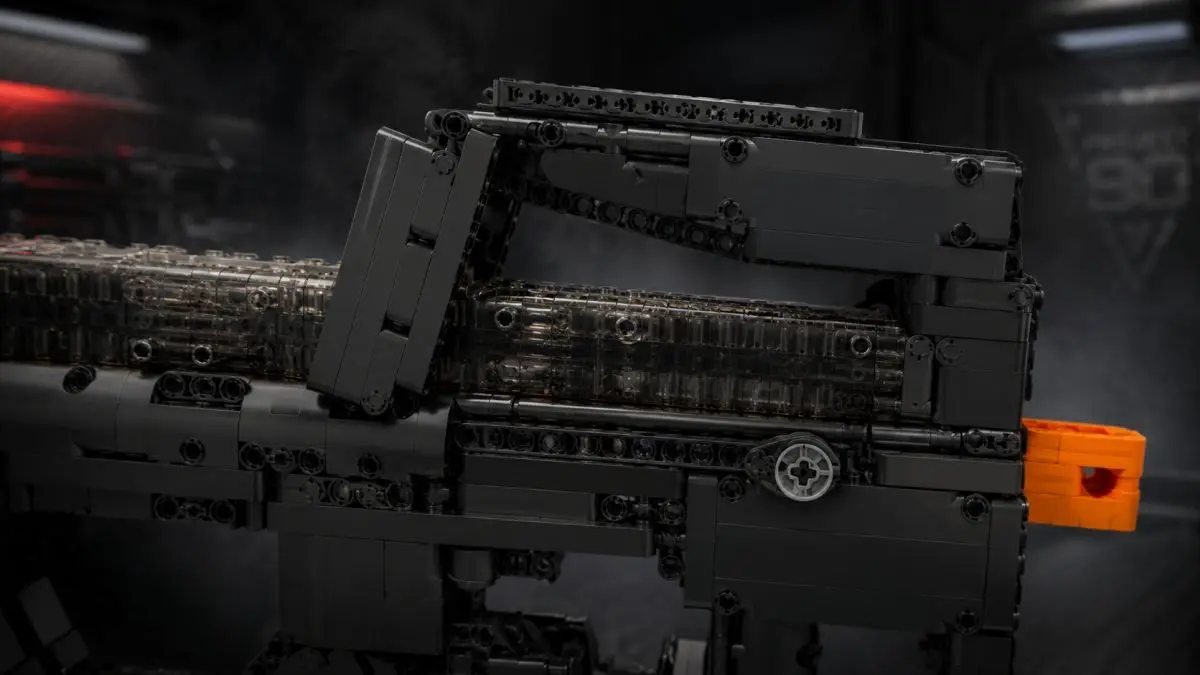 Detail horní části černého samopalu z kostek s průhlednými prvky mechanismu.