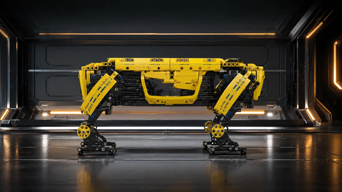 Side view of a yellow brick-built robot with four articulated legs.