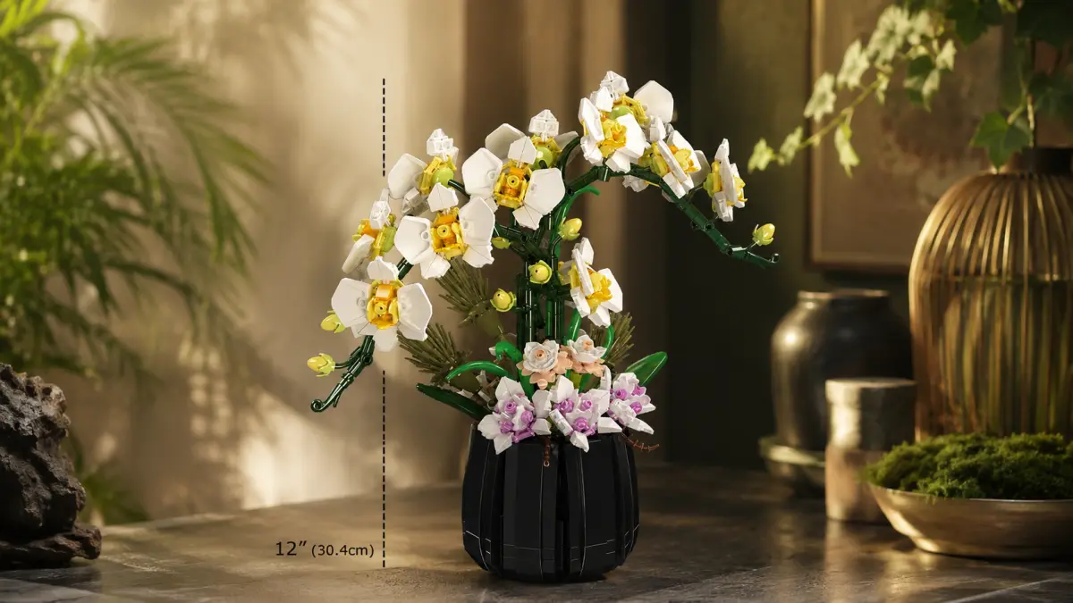 Orqu&iacute;dea branca de blocos num vaso preto sobre uma mesa, entre vegeta&ccedil;&atilde;o e decora&ccedil;&atilde;o